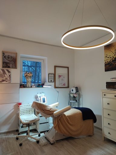 Behandlungsraum im NK-Studio Hannover-Kleefeld mit moderner Kosmetikliege, Ring-Pendelleuchte und ruhiger Wohlfühlatmosphäre.